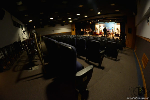 Cadeiras em auditório com banda ensaiando