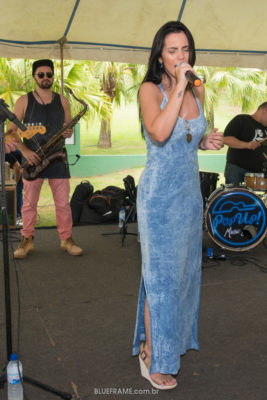 cantora com microfone e vestido longo azul